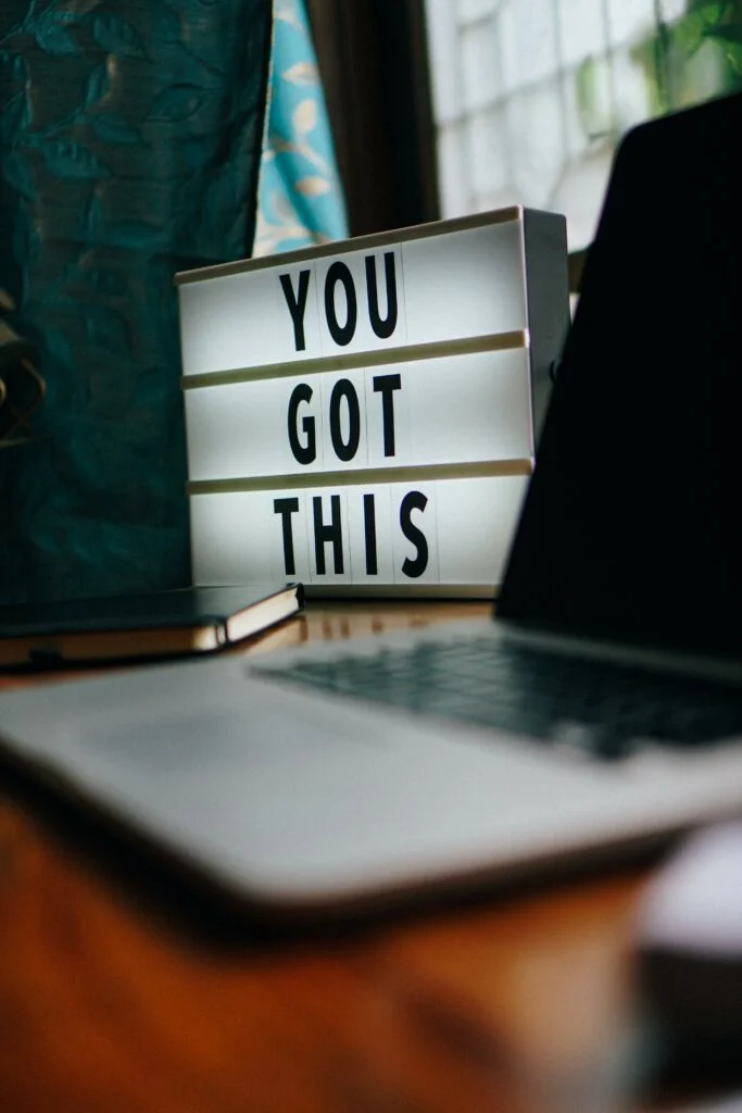 Desk with a laptop, diary and sign saying 'You Got This'